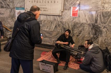 Москва. Мужчина играет на ситаре на станции метро `Арбатская`.
