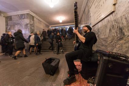 Москва.  Мужчина  играет на ситаре на станции метро `Арбатская`.