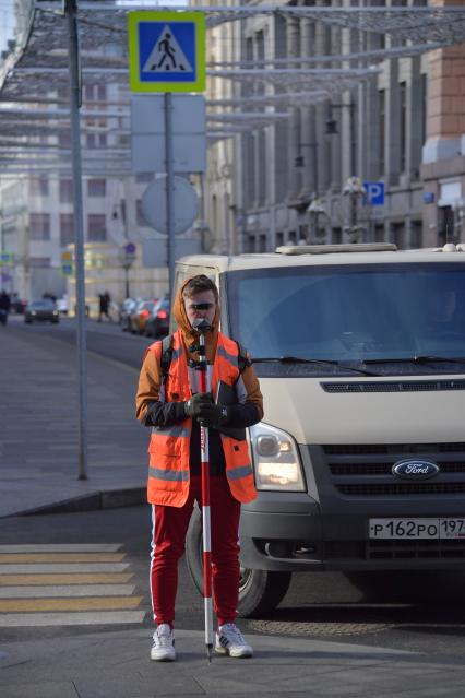 Москва. Геодезист на улице города.