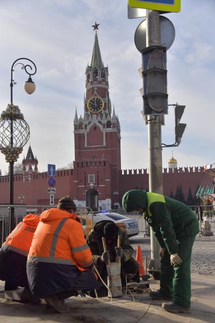 Москва. Рабочие укладывают плитку в районе  Красной площади.