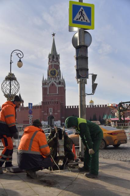 Москва. Рабочие укладывают плитку в районе  Красной площади.