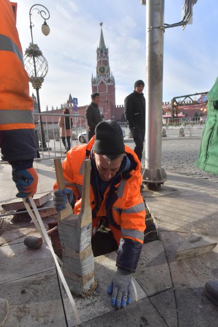 Москва. Рабочие укладывают плитку в районе  Красной площади.