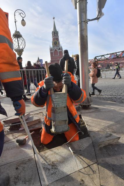 Москва. Рабочие укладывают плитку в районе  Красной площади.