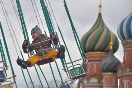 Москва. Дети катаются на карусели на Красной площади.