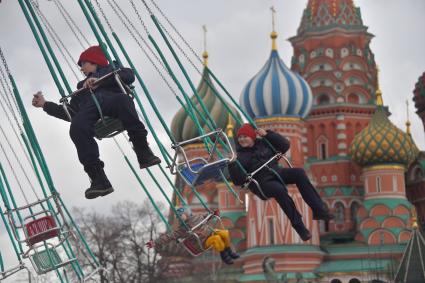 Москва. Дети катаются на карусели на Красной площади.