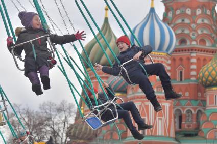 Москва. Дети катаются на карусели на Красной площади.