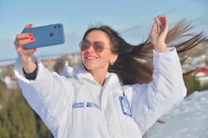 Ханты-Мансийск. Девушка фотографируется на мобильный телефон.