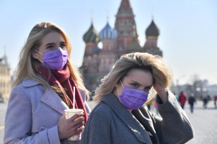 Москва.   Девушки в медицинских масках на Красной площади.