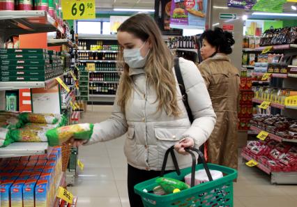 Иркутск. Девушка в медицинской маске в продуктовом магазине.