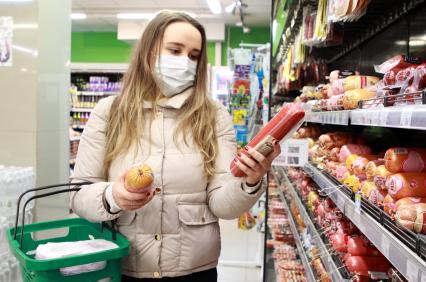 Иркутск. Девушка в медицинской маске в продуктовом магазине.