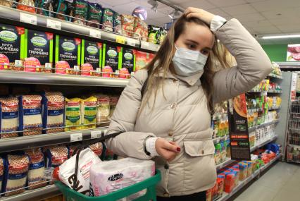Иркутск. Девушка в медицинской маске в продуктовом магазине.