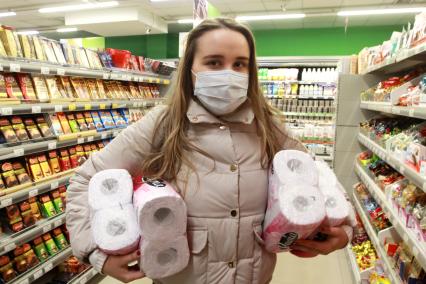 Иркутск. Девушка в медицинской маске в продуктовом магазине.