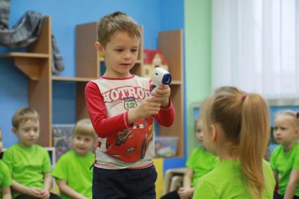 Красноярск. Мальчиу измеряет температуру бесконтактным термометром.