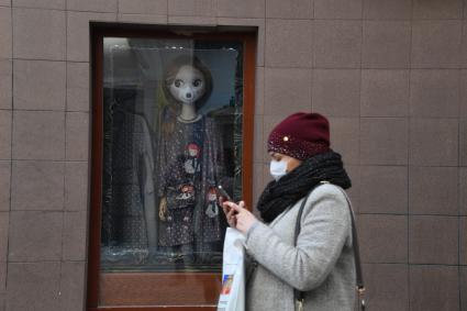Москва. Женщина в медицинской маске на улице города.