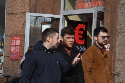 Москва. Мужчины у обменного пункта валюты.