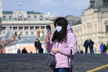 Москва. Женщина в медицинской маске на улице города.