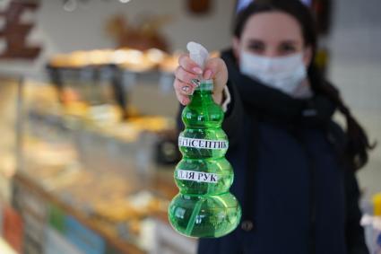 Самара. Девушка в медицинской маске в продуктовом магазине  с антисептиком.