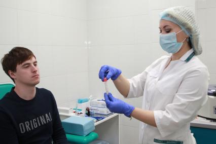 Иркутск. Медицинский работник берет анализ на коронавирус.