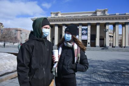 Новосибирск.  Молодые люди в медицинских масках на улице.