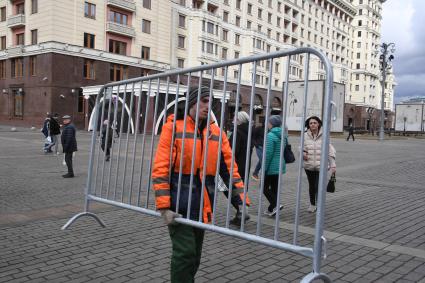 Москва. Сотрудники коммунальных служб несут ограждения на Манежной площади.