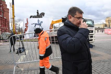 Москва. Сотрудники коммунальных служб несут ограждения на Манежной площади.