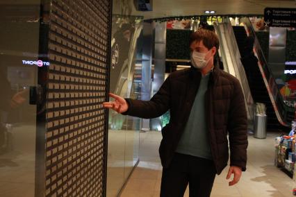 Иркутск. Мужчина в медицинской маске у закрытого кафе в торговом центре.