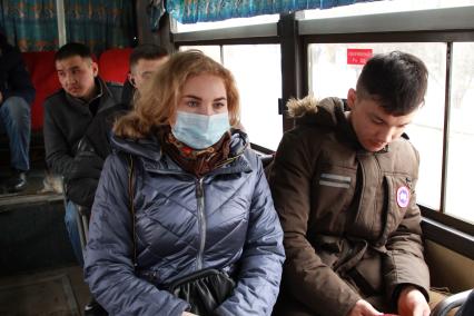 Иркутск. Девушка в медицинской маске едет в общественном транспорте.