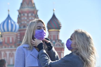 Москва.   Девушки в медицинских масках на Красной площади.