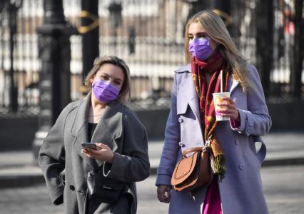 Москва.   Девушки в медицинских масках у Александровского сада.