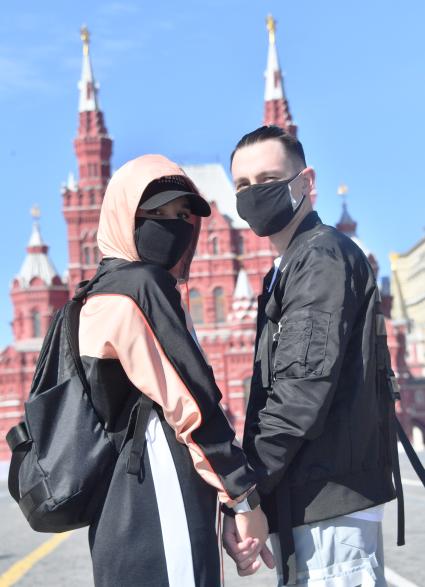Москва. Молодые люди в медицинских масках на Красной площади.