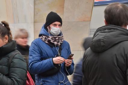 Москва.    Молодой человек в медицинской маске в метро.