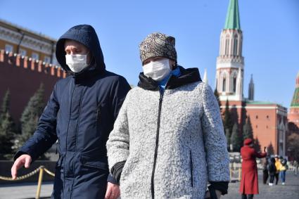 Москва.   Мужчина и женщина  в медицинских масках на Красной площади.