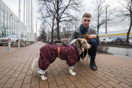 Москва. Молодой человек выгуливает собаку.