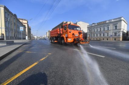 Москва.  Автомобиль коммунальной службы моет улицу.