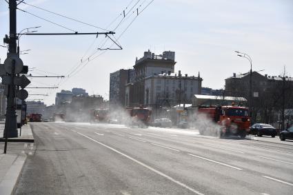 Москва.  Автомобили коммунальной службы моют улицу.