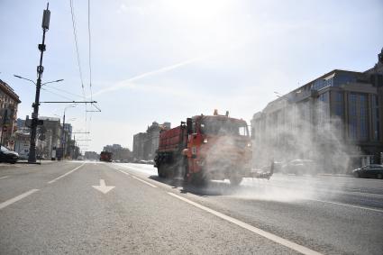 Москва.  Автомобили коммунальной службы моют улицу.