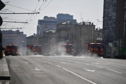 Москва.  Автомобили коммунальной службы моют улицу.