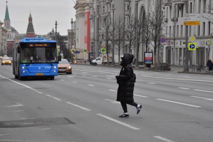 Москва.  Девушка переходит Тверскую улицу.