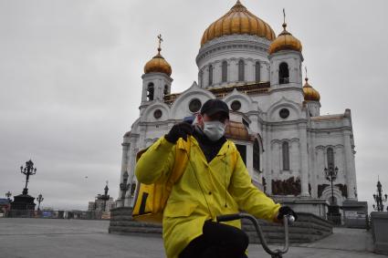 Москва.   Сотрудник сервиса по доставке еды `Яндекс Еда` у Храма Христа Спасителя.