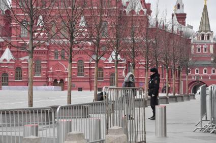 Москва.   Полицейский на Красной площади разговаривает с женщиной.