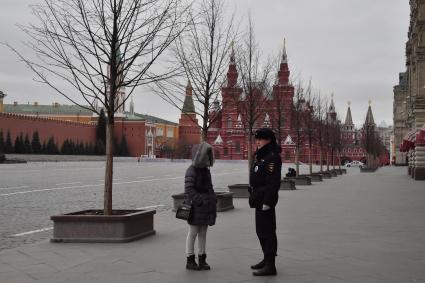 Москва.   Полицейский на Красной площади разговаривает с женщиной.