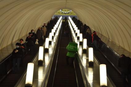 Москва.   Сотрудник сервиса по доставке еды `Деливери клаб` на эскалаторе московского метрополитена.