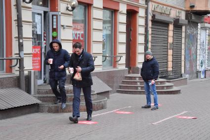 Москва.   Мужчины выходят из кафе KFC на Старом Арбате.