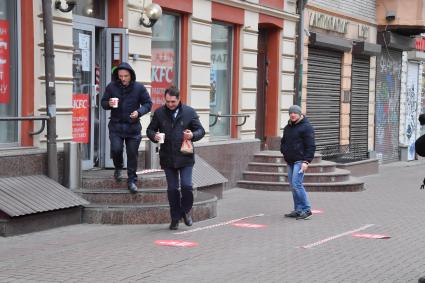 Москва.   Мужчины выходят из кафе KFC на Старом Арбате.