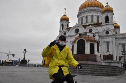 Москва.   Сотрудник сервиса по доставке еды `Яндекс Еда` у Храма Христа Спасителя.