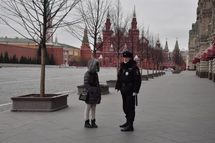 Москва.   Полицейский на Красной площади разговаривает с женщиной.