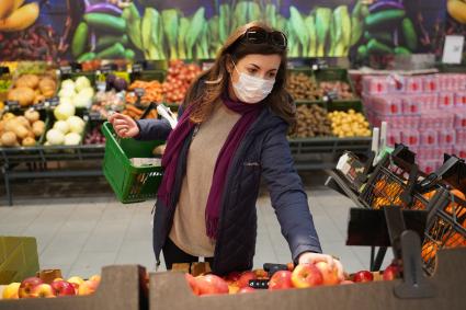 Самара. Девушка в медицинской маске в продуктовом магазине.