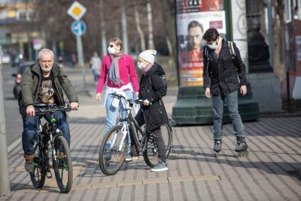 Москва.   Люди в медицинских масках на улице города.