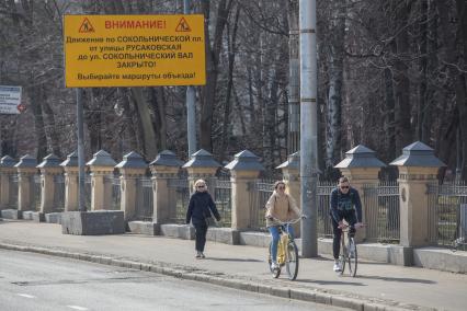 Москва.  Мужчина и женщина едут на велосипедах.