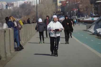 Самара.  Женщина на самокате на улице города.